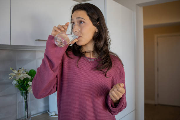 istock Young woman taking vitamins 1440480833
