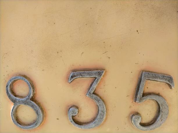 istock Number eight hundred and thirty five,835 in metal numerals on a beige surface with copy space 1440481660