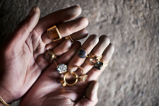 Jewelry maker, hands and gold rings showing creative work and craft of goldsmith in a workshop. Closeup of designer or jeweler in accessory manufacturing industry as art, job or hobby with gemstones