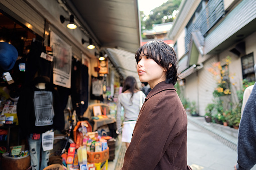 Young woman walking on the shopping street of Enoshima Island