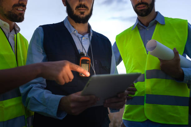 istock Close up of irrecognizable group of engineers and maintenance workers looking at digital tablet together discuss plans. 1440486163