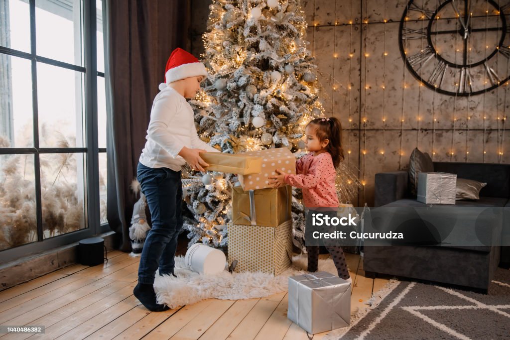 Foto de Criança Garota Caixa De Presente Presente Árvore Presentes De Natal  Sala De Estar Alegre Felicidade Natal Fundo De Natal Árvore De Natal  Sorridente Feliz Cabrito Árvores Decoração De Natal Luzes