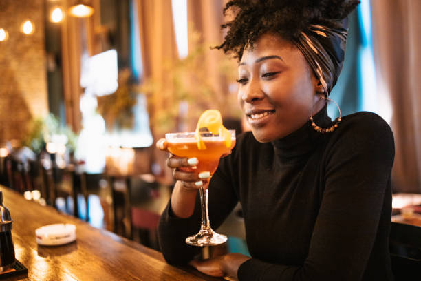 African woman drinking cocktail stock photo
