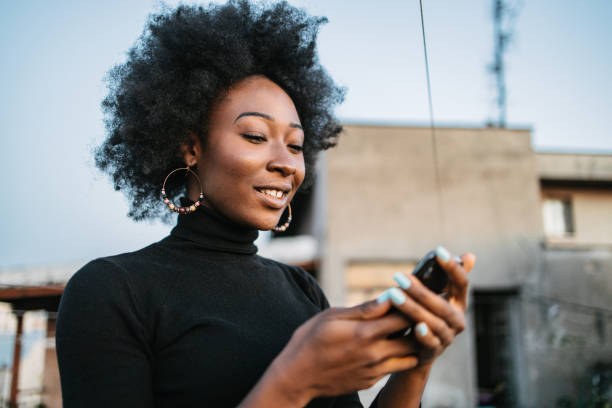 istock African woman looking at her phone 1440487744