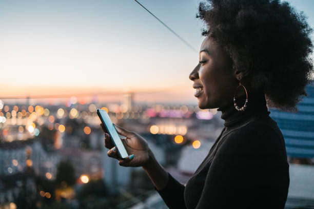 African woman looking at her phone stock photo