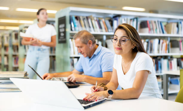istock Female Latina college student working on a project with a male elder 1440488270