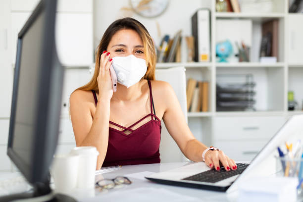 istock Businesswoman in face mask using phone 1440488638