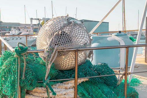 Professional fishing boat anchored in the Monopoli dock with traditional fishing gear on deck.