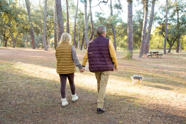 istock Mature couple walking in the forest with a dog 1440491823