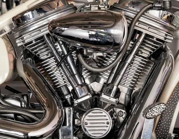 Closeup shiny chrome details of modern motorcycle motor parked in garage in daytime