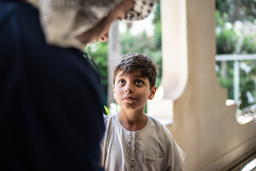 Little Arab boy listening his brother at home