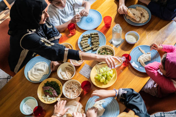 家で一緒に昼食をとるイスラムの家族のハイアングルビュー - family grape ストックフォトと画像