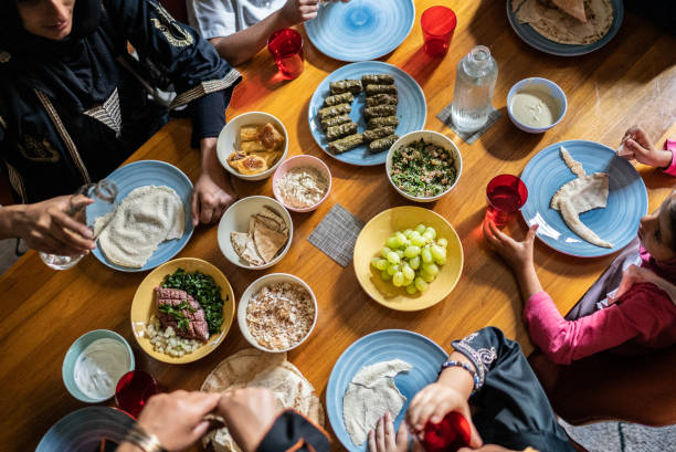 widok z dużego kąta na islamską rodzinę jedzącą razem lunch w domu - family grape zdjęcia i obrazy z banku zdjęć