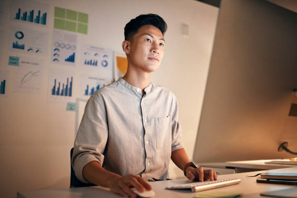 istock Marketing startup Asian businessman on computer for data analysis, planning or research creative innovation strategy at night in office. Tech, worker or employee on desktop for agenda or SEO review 1440496556