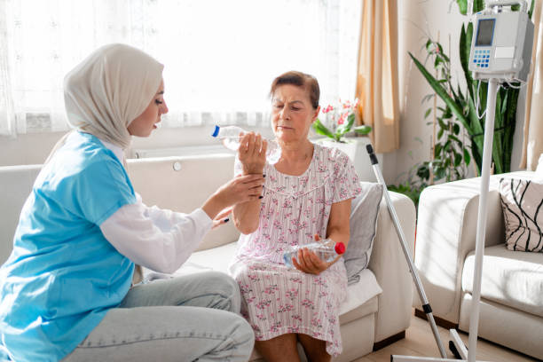 istock Older aged woman doing physiotherapist with support from muslim  nurse 1440497346