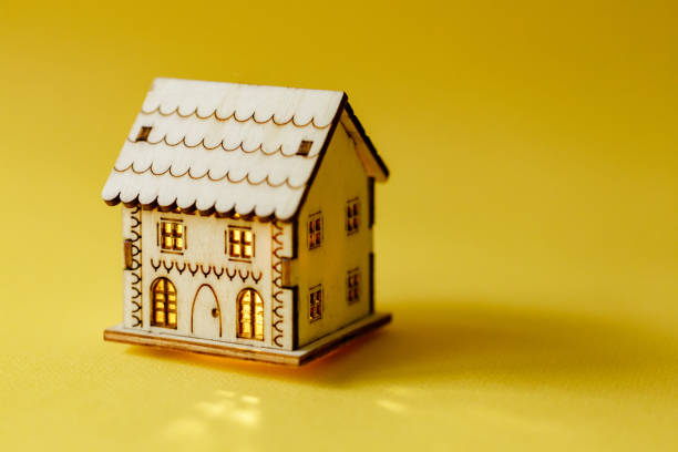 istock Wooden model house on yellow background 1440499152