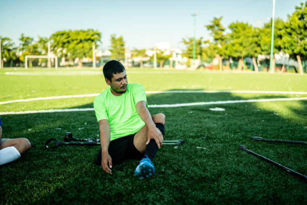 istock Young amputee soccer player sitting on soccer field 1440501304