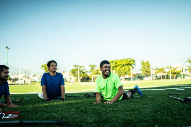 istock Amputee soccer players stretching while talking on soccer field 1440502617