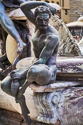 Neptune statue on the Neptune fountain in Florence from behind. The Fountain of Neptune is situated in the Piazza della Signoria in front of the Palazzo Vecchio. The fountain was commissioned by Cosimo I de' Medici in 1559.
