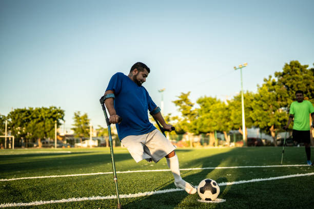 un joueur amputé adulte frappe un tir de pénalité sur un terrain de soccer - penalty shot photos et images de collection