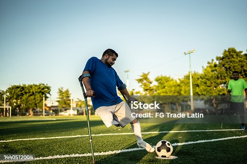 istock Mid adult amputee player hitting penalty kick on soccer field 1440512004