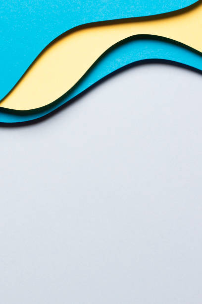 istock Abstract colored paper texture background. Minimal paper cut composition with layers of geometric shapes and lines in yellow and light blue colors. Top view 1440513971
