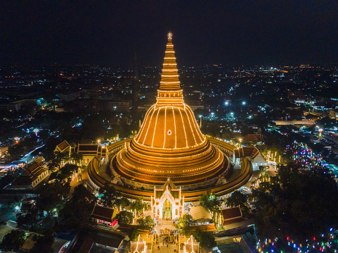 A massive golden pagoda Located in the sunset community of Phra Pathom Chedi, Nakhon Pathom, Thailand. The measurement was made public. Thailand aerial view of a road roundabout with auto lots. Lovely