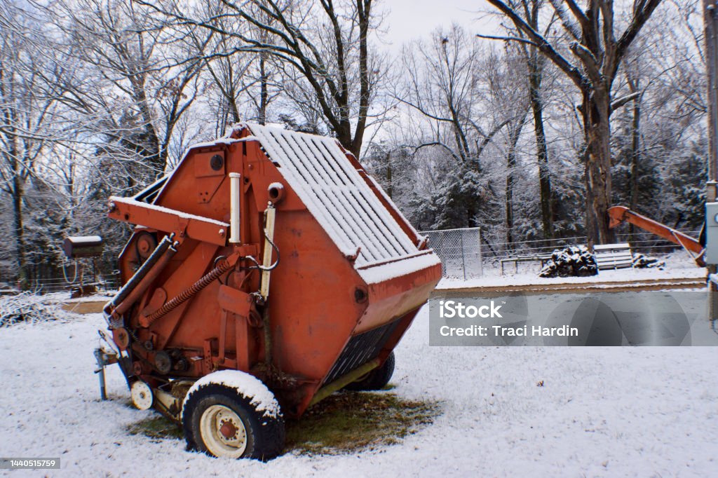 A round hay baler on a farm covered in snow A round hay baler covered in snow Hay Baler Stock Photo
