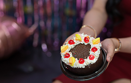 girl's hand holding a birthday cake Focus on the happy moments