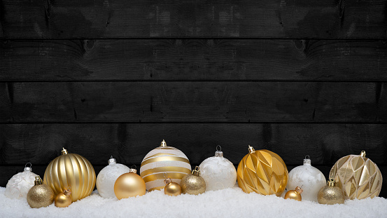 Festive christmas ornaments advent celebration holiday holidays banner greeting card - Collection of many golden and white christmas baubles, christmas balls on snow, with black wooden wall in background