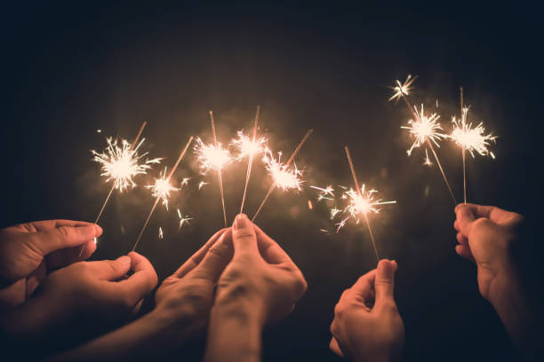 group of friends enjoying themselves with sparklers in the photo stock photo