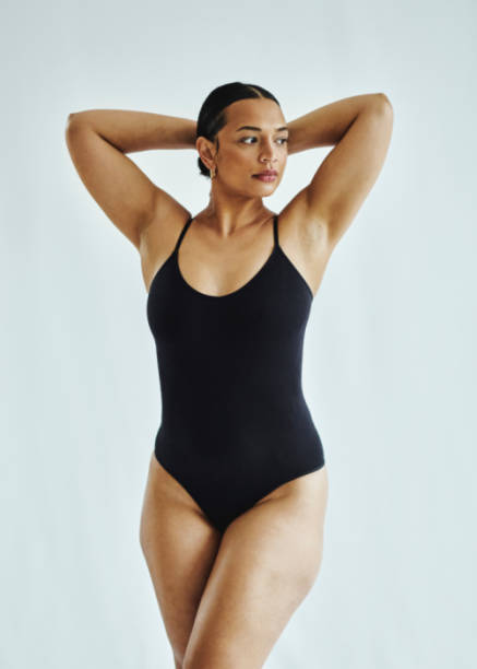 Body positive, woman with curvy body in studio on a grey background. Normal beauty and skincare with feminism and empowerment, feeling comfortable in skin and underwear Body positive, woman with curvy body in studio on a grey background. Normal beauty and skincare with feminism and empowerment, feeling comfortable in skin and underwear black woman bathing suit stock pictures, royalty-free photos & images