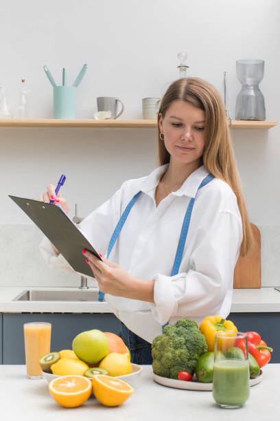 istock A nutritionist writing a diet plan looks down on fresh fruits and vegetables. 1440523713