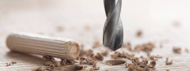 istock drill bit makes hole in wooden oak board for wooden dowel. 1440525625