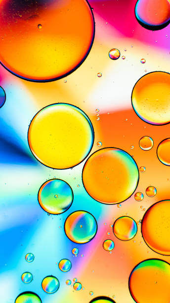 istock Vertical macro shot of different sized bubbles on a colorful background 1440531594