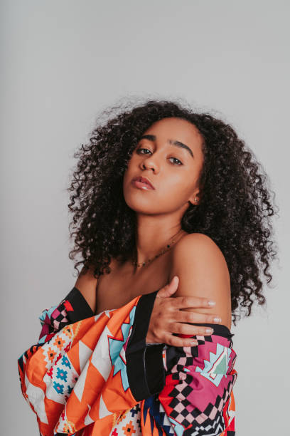 istock Vertical shot of a Hispanic female dressed casually while posing by a white background 1440532191