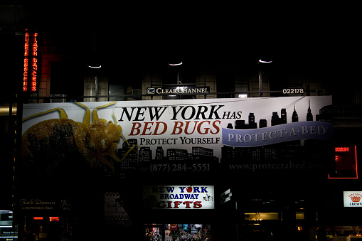 NYC, United States – December 23, 2020: New York Bed Bugs ad at night on a busy street in NY