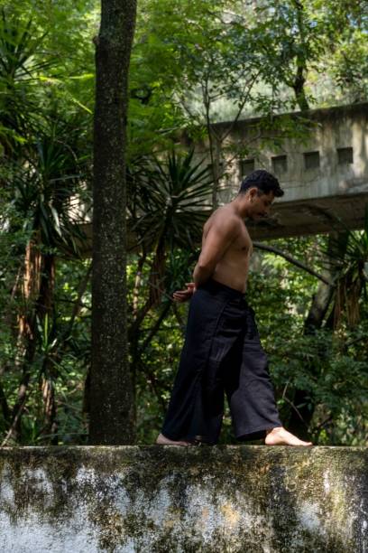istock Vertical shot of a Hispanic man practicing yoga outdoors surrounded by green vegetation. 1440532507