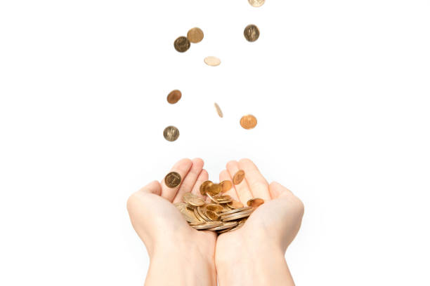 istock Various coins falling into a persons hands isolated on a white background 1440532944