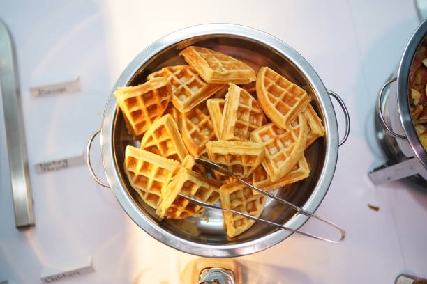 istock Top view of a metallic bowl filled with belgian waffle on a white table 1440535472
