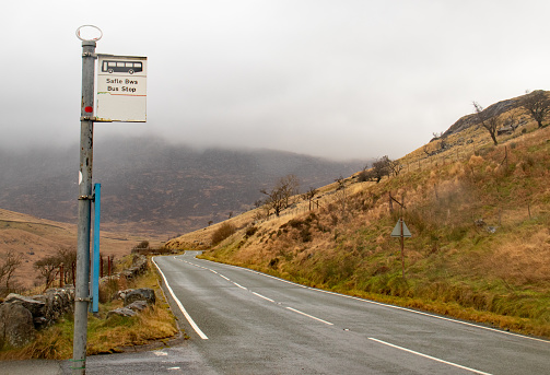 A bus stop surrounded by hills covered in the fog in Snowdonian National Park, Wales