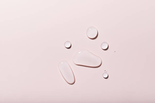 istock Top view closeup of multiple water drops on a light purple background 1440536351