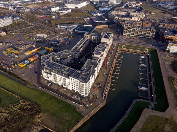 Cityscape aerial real estate and urban development Zutphen, Netherlands – December 13, 2020: Construction site, residential building and recreational port in the Noorderhaven neighbourhood of Zutphen. panoramic riverbank architecture construction site stock pictures, royalty-free photos & images
