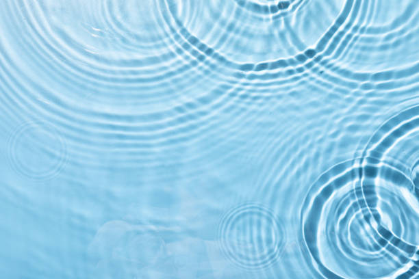 istock Top view closeup of waterdrops falling on the surface and forming a circular shape 1440536415