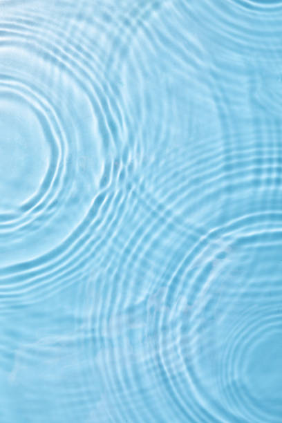 istock Top view closeup of waterdrops falling on the surface and forming a circular shape 1440536420