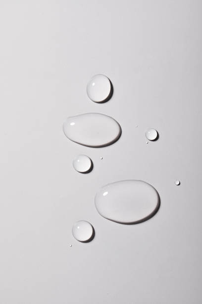 istock Top view closeup of multiple water drops on a light greybackground 1440536497