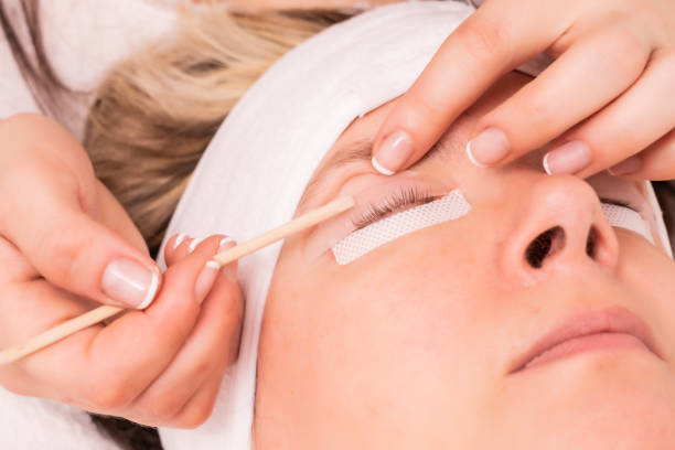 istock Skillful cosmetologist doing lash extension procedure - Beauty concept 1440537201