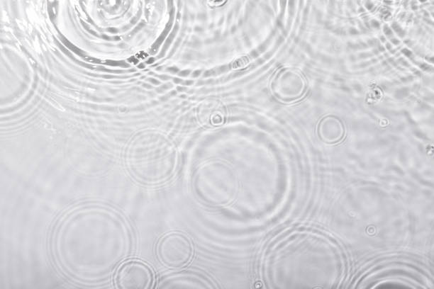 istock Top view closeup of waterdrops falling on the surface and forming a circular shape 1440537280