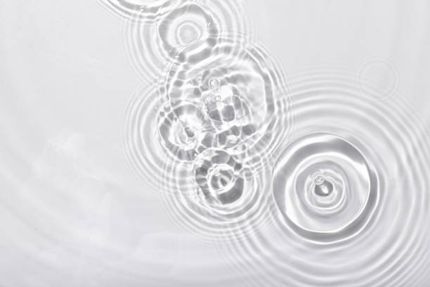 istock Top view closeup of waterdrops falling on the surface and forming a circular shape 1440537310