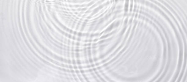 istock Top view closeup of waterdrops falling on the surface and forming a circular shape 1440537314